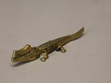 un petit lézard doré posé sur une table