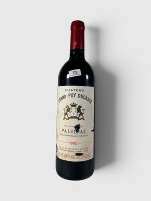 la bouteille de vin rouge est posée sur une surface blanche