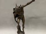 statue en bronze représentant un homme tenant un couteau dans chaque main