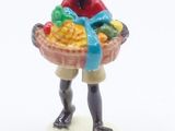 a figurine of a boy holding a basket of fruit