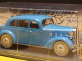 a blue toy car in a clear box on a yellow surface