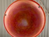 underside view of a red and orange bowl hanging from a ceiling