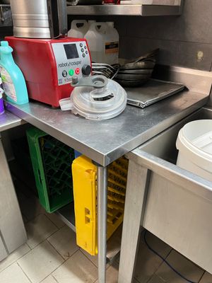 une petite cuisine équipée d'un évier et d'un plan de travail sur lequel se trouve un mixeur