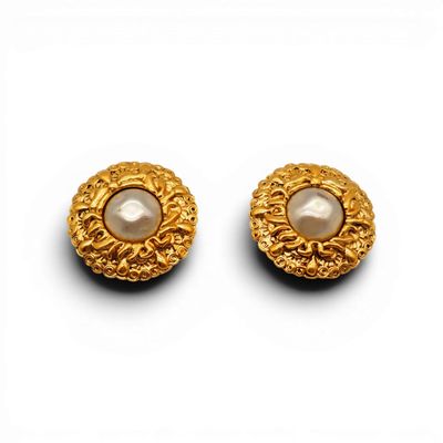 une paire de boucles d'oreilles en or et perles sur fond blanc