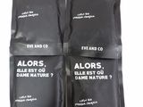 three bags of coffee sitting on top of each other on a table