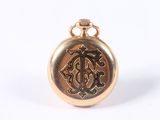an image of a gold pocket watch with a monogram on it