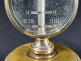 an old fashioned thermometer is on top of a black surface