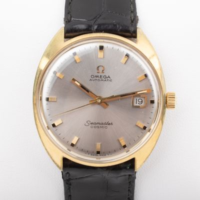 an image of a gold and black watch on a white surface