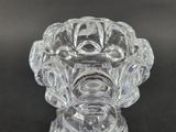a clear glass candle holder on a black table