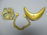 two pieces of gold and silver jewelry on a white surface