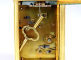 a gold clock with a key in the middle of it
