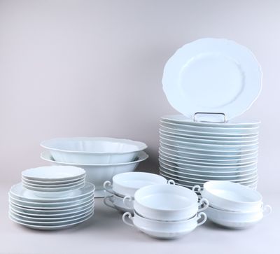 a lot of white plates and bowls on the table