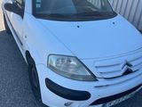 la petite voiture blanche est garée devant un bâtiment