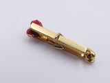 a small gold pin with a red cord on it