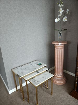 trois tables placées à côté d'un vase contenant des fleurs