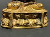 a gold statue of a person sitting on top of a table