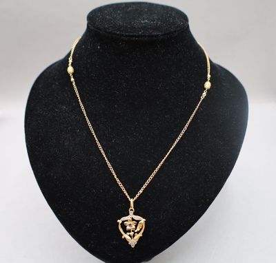 un collier en or avec un pendentif en forme de cœur sur un mannequin noir
