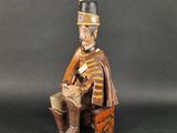 a wooden statue of a soldier sitting on a chair