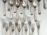 beaucoup de cuillères et de fourchettes en argent sur une table