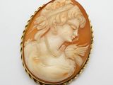 un camée ancien en coquillage représentant une femme portant un collier de perles