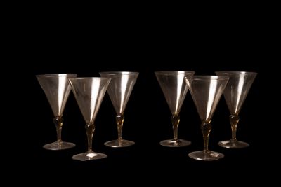 quatre verres à vin sont alignés sur un fond noir
