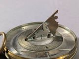 a close up of a pocket watch on a table