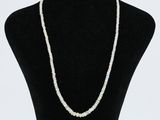 un collier de perles blanches autour du cou d'un mannequin noir
