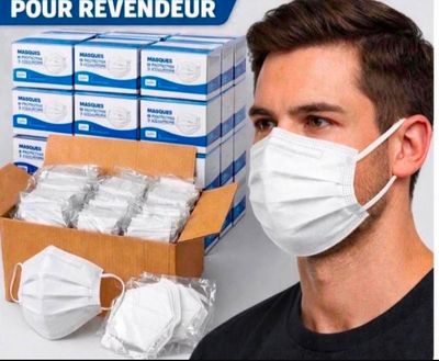 a man wearing a face mask next to a box of face masks