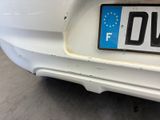 a close up of a license plate on a white car
