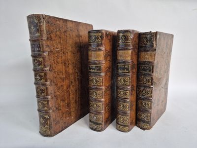 three old books sitting on top of each other on a white surface