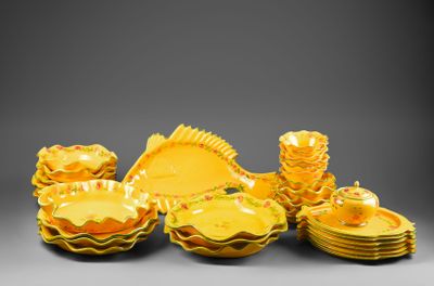 a lot of yellow dishes and cups on the table