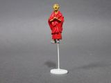 figurine of a monk on a stand with a red robe