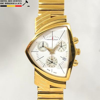 une montre en or avec un cadran blanc et un bracelet en or