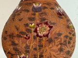 a vase that has flowers painted on it