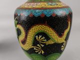 a vase with a dragon painted on it sitting on a table