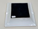 a small square plate with a black square on it