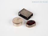 two silver and garnets sitting next to each other on a white surface