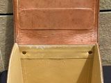 a brown suitcase sitting on a table next to a wall