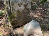 a large rock sitting on the ground next to a large rock