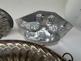 a silver plate with a bird on it next to a silver plate with a bird on it