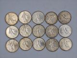 a bunch of silver coins sitting on top of a white surface