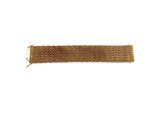 gros plan d'un bracelet en or sur fond blanc