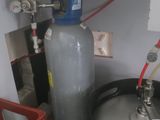 a water tank and a keg in the corner of a room