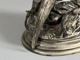 silver plated figurine of a bird on a branch with feathers