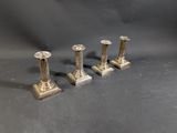 three silver candles are sitting on a table with a gray background