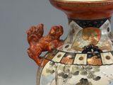 a vase with a painting on it sitting on a table