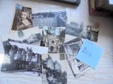 une pile de vieilles photos posée sur une table à côté d'un ordinateur portable