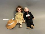 two dolls sitting next to each other on a table