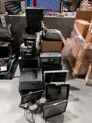 un tas d'ordinateurs et d'autres équipements électroniques dans un entrepôt