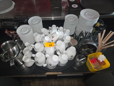 de nombreuses tasses et soucoupes posées sur un plateau sur le comptoir